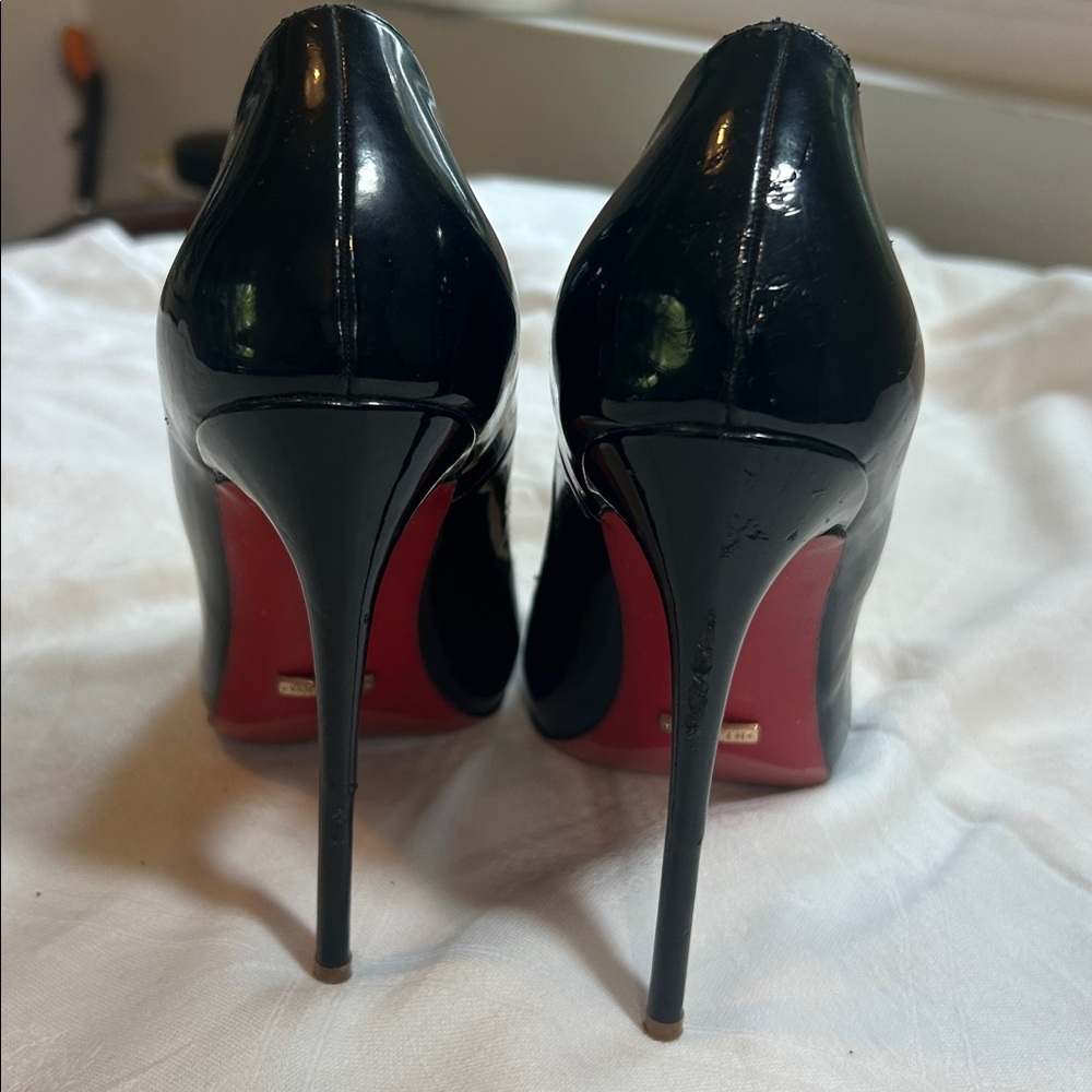 H L TINO Black patent stiletto Heels with red soles.